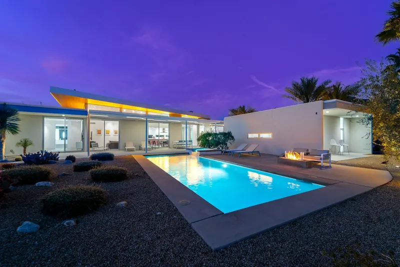 Modern home with a pool at dusk