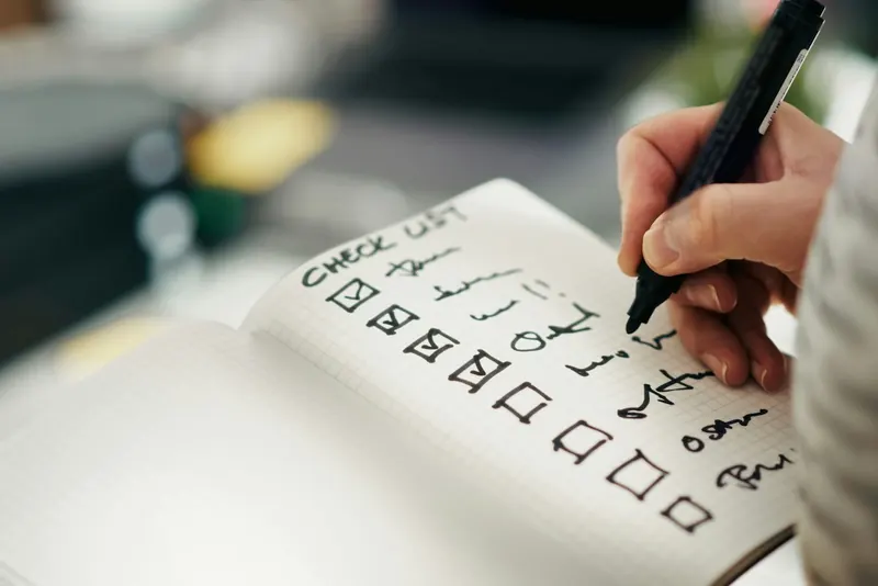 Hand writing a checklist in a notebook